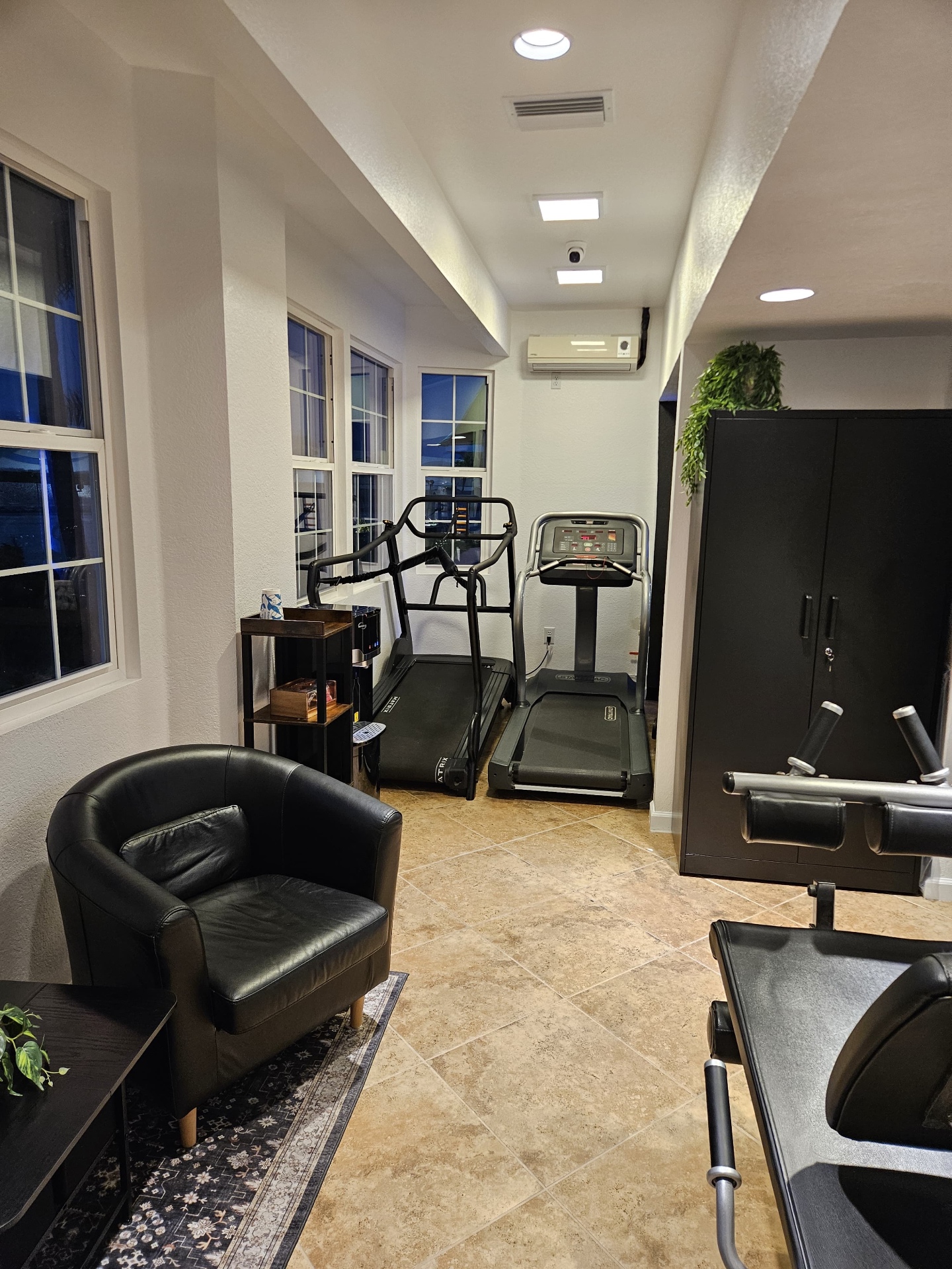 Wide interior view of the On Point Fitness private training studio, featuring weight racks and equipment.